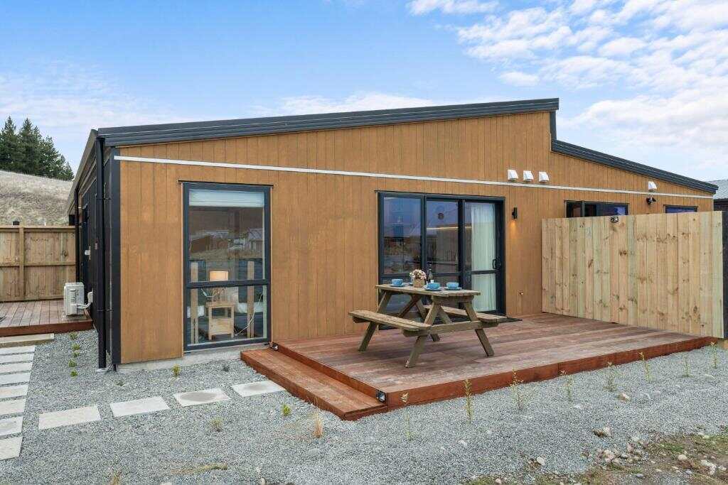 Exterior of Sunshine Suites with a private deck and picnic table